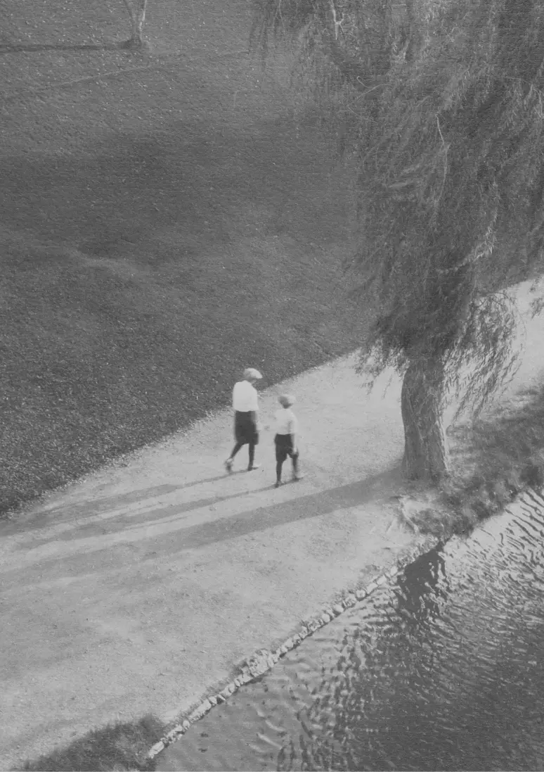 Foto in bianco e nero che ritrae una donna e un bambino da lontano.